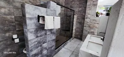 a bathroom with a shower and a toilet and towels at Mountain Dreamers in Hartbeespoort