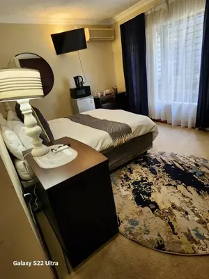 a bedroom with a bed and a table with a lamp at Mountain Dreamers in Hartbeespoort