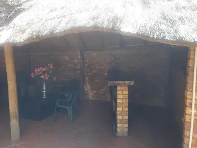 a patio with a table and a chair and a brick wall at American horses in Pretoria