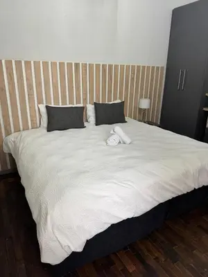 a large white bed with a stuffed animal on it at Kioma Guest House in Mokopane