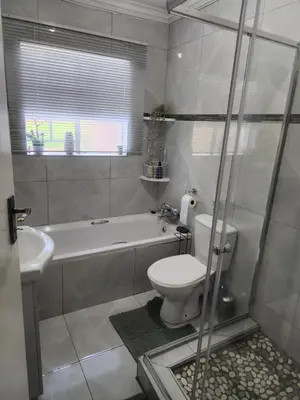 a bathroom with a toilet and a tub and a sink at Olympia in Pretoria