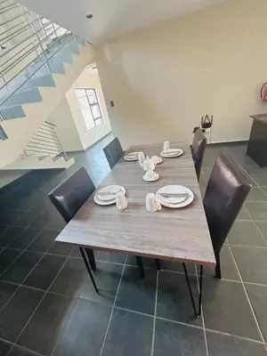 a wooden table with chairs and plates and dishes on it at Chill Out in Malelane