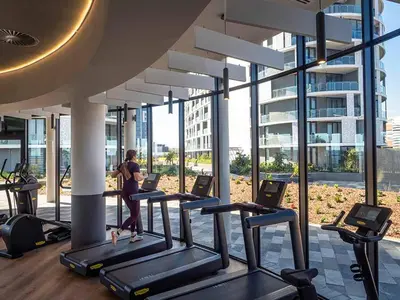 a woman running on treadmills in a gym at 2115 Kepler, Ellipse - Serene Luxury in Midrand