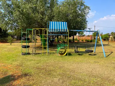 a playground with a blue and white chair and swings at Bobisemo Luxury Guesthouse in Tierpoort