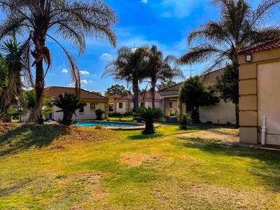 a house with palm trees and a swimming pool at Bobisemo Luxury Guesthouse in Tierpoort