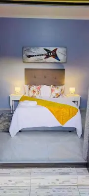 a bedroom with a large bed with two tables at Morodi Guest Lodge in Witbank