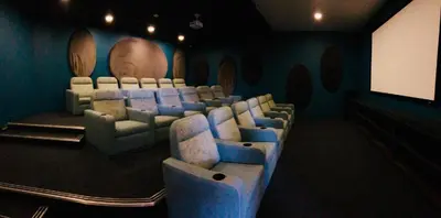 a cinema room with chairs and a projection screen at The Blyde Tranquil Mint Resort Pretoria in Pretoria