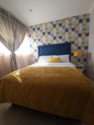 a bedroom with a bed with a blue headboard and a window at Calm house by the river in Brits