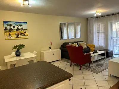 a living room with a couch and a table at 2e - No load shedding 2 bed home to relax into in Centurion