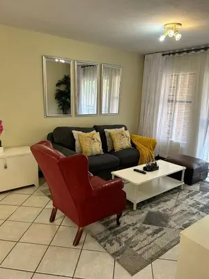 a living room with a couch and a coffee table at 2e - No load shedding 2 bed home to relax into in Centurion