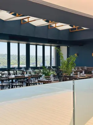 a restaurant with tables and chairs and windows at French love, Menlyn Maine in Pretoria
