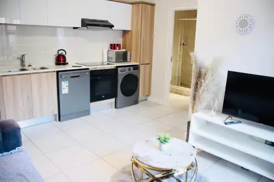 a kitchen with a washing machine and a table at The blyde crystal lagoon 116 in Pretoria