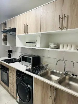 a kitchen with a sink and a stove and a dishwasher at Homely Stay 3 in Kempton Park
