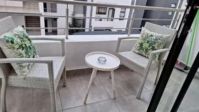a balcony with chairs and a table and a tub at Luxury Apartments in Midrand