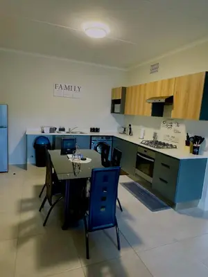 a kitchen with a table and chairs in a room at Dimension in Midrand