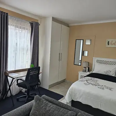 a hotel room with a bed and a desk at The Luxury stay in Midrand
