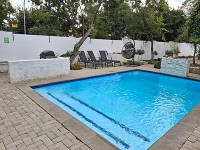 a swimming pool with blue water in a yard at 118 Bayley Street in Benoni