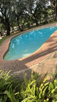 a large pool of blue water in a yard at Cottage 3 at Cynthias Country in Hartbeespoort