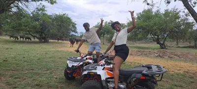 two men are standing next to atvs in a field at Casa de la Presa 5 in Polokwane