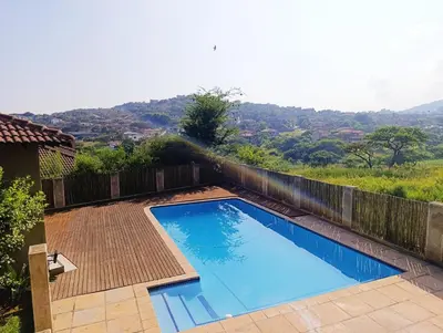 a large blue swimming pool with a wooden fence at Elephant villa 5 bedroom in Nelspruit
