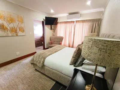 a hotel room with a bed and a chair at Elephant villa 5 bedroom in Nelspruit