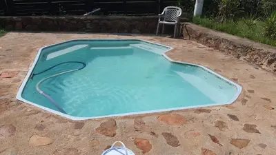 a small swimming pool in a yard with a chair at Chalet 1 Camping Style at Cynthias Country Farmstay Outside bathroom in Hartbeespoort
