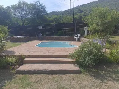 a small swimming pool in a yard with a fence at Chalet 1 Camping Style at Cynthias Country Farmstay Outside bathroom in Hartbeespoort