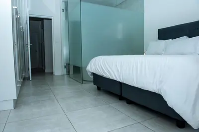 a bedroom with a large bed and a mirror at Feelathome in Midrand