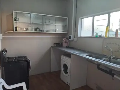 a kitchen with a sink and a washing machine at Claremont Secured unit in Pretoria