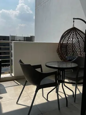 a table and chairs on a balcony with a swing at The Sactuary in Midrand