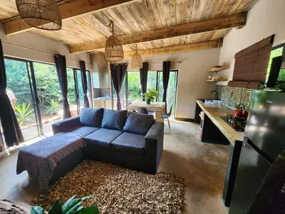 a living room with a couch and a table at Hartbeest Bush Stay #6 in Hartbeespoort