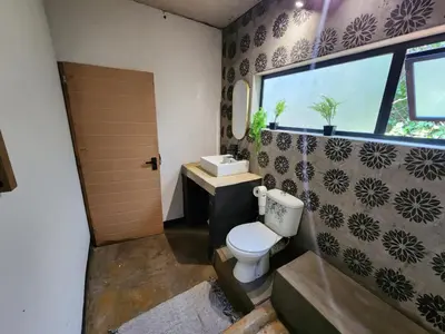 a bathroom with a toilet and a sink and a window at Hartbeest Bush Stay #6 in Hartbeespoort