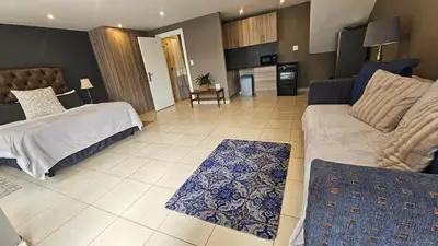 a living room with a bed and a couch at Belle Vie Boutique Guesthouse in Pretoria