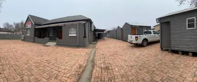 a brick parking lot with houses and a truck at Relax Guest House in Ermelo