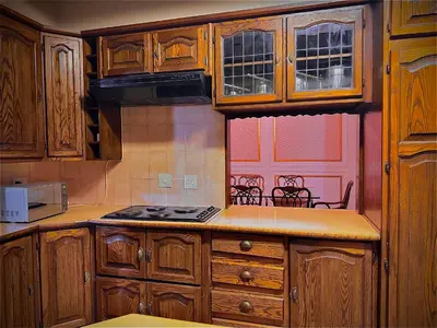 a kitchen with wooden cabinets and a stove top oven at The Loraine Luxury Villa in Witbank