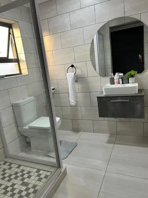 a bathroom with a toilet and a sink and a mirror at Okuhle guesthouse in Mahlakwena