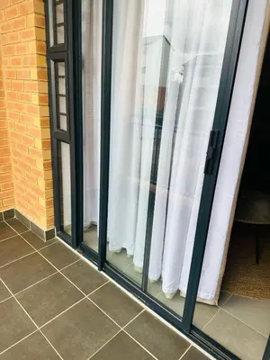 a group of glass windows with white curtains at Calm & Cozy Apartment 2 in Pretoria