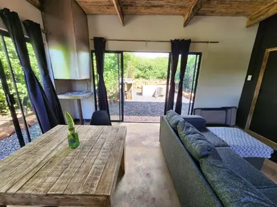 a living room with a couch and a wooden table at Hartbeest Bush Stay #28 in Hartbeespoort