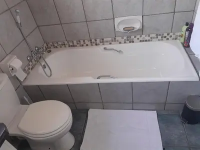 a bathroom with a toilet and a bath tub at 2 bedroom family friendly cosy & luxury home, walking distance to Doringkloof Mall in Centurion