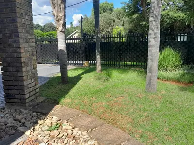 a fence in a yard with trees and grass at 2 bedroom family friendly cosy & luxury home, walking distance to Doringkloof Mall in Centurion