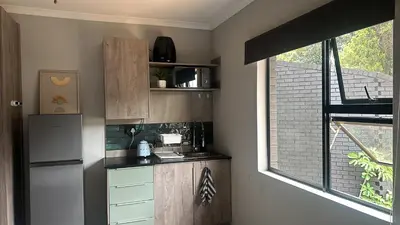 a kitchen with a refrigerator and a window at Core accomodations in Pretoria