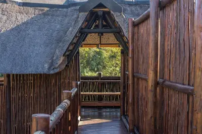 an entrance to a wooden building with a thatch roof at Kruger Park Lodge Unit No 303 in Hazyview