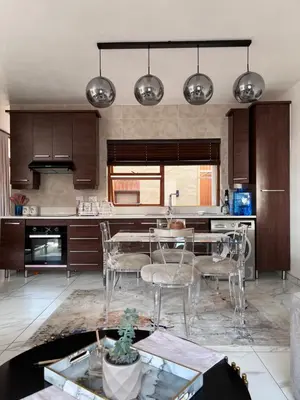 a kitchen with a table and chairs in it at Cosy 3 bedroom apartment In Pretoria East in Pretoria