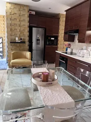 a kitchen with a glass table in a kitchen at 3 bedroom holiday apartment in Pretoria East in Pretoria