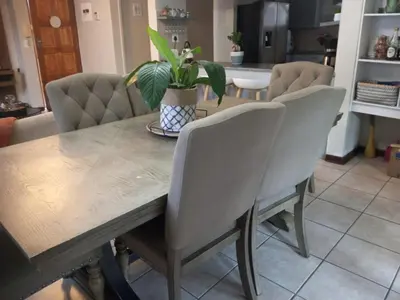 a dining room table with chairs and a potted plant at Simply Stay in Polokwane