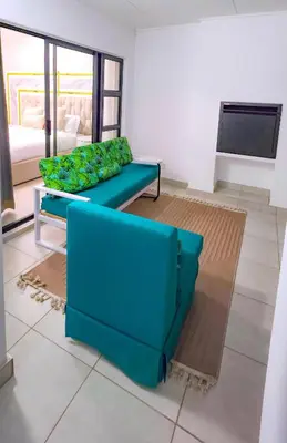 a living room with a blue couch and a tv at THE BLYDE CRYSTAL LAGOON F&S LUxurious Apartment 3bed in Pretoria