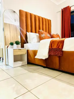 a large bed with a large headboard in a room at Beach-Style Bliss at The Blyde in Pretoria