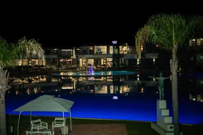 a hotel swimming pool at night with a statue next to it at The Blyde 3bed Beach Facing F&S Luxurious 2 in Pretoria