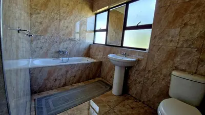 a bathroom with a tub and a sink and a toilet at 7 Heaven Boutique Hotel in Burgersfort