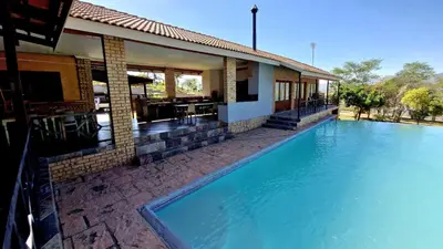 a large swimming pool in front of a house at 7 Heaven Boutique Hotel in Burgersfort